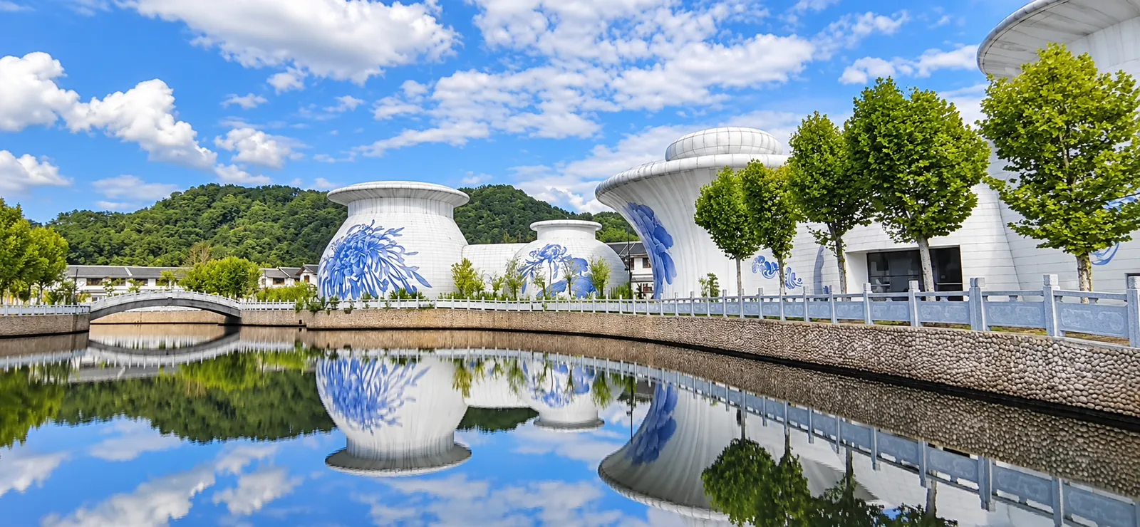 白天的瓷器造型建筑与水面倒影